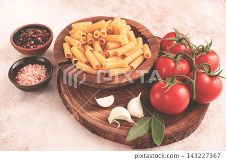 Pasta ingredients spread out, on a wooden surface, with tomatoes and spices, ready to cook, there are no people Pasta ingredients spread out, on a wooden surface, with tomatoes and spices, ready to cook, there are no people 143227367