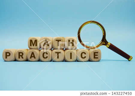 Math Practice alphabet letters wooden cube and magnifying glass on blue background Math Practice alphabet letters wooden cube and magnifying glass on blue background 143227450