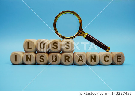 Loss Insurance alphabet letters wooden cube and magnifying glass on blue background Loss Insurance alphabet letters wooden cube and magnifying glass on blue background 143227455