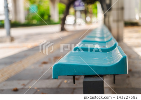 Turquoise Public Benches Along Blurred Urban Walkway Turquoise Public Benches Along Blurred Urban Walkway 143227582