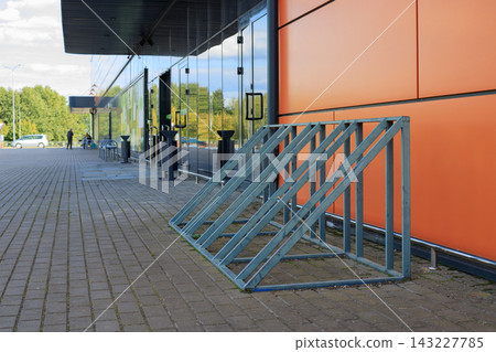 Empty Bike Parking Stand at Entrance of Supermarket Building for Retail Shopping Convenience Concept Empty Bike Parking Stand at Entrance of Supermarket Building for Retail Shopping Convenience Concept 143227785