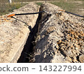 Excavation. A shovel left in a narrow excavated trench. Manual labor, landscaping, or groundwork for utility installation. 143227994