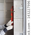 measuring wall flatness using a bubble level. Construction and renovation concept 143227996
