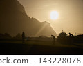 Golfers Silhouetted at Sunset on Scenic Coastal Course 143228078