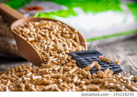 Wood Pellets And Calculator On Table Representing Biofuel Heating Costs And Renewable Energy Budgeting 143228250