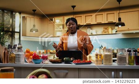 African American food influencer preparing avocado and toast with a toaster, meal prep at counter indoors. Woman vlogger filming culinary recipe and tutorial, healthy food breakfast idea. African American food influencer preparing avocado and toast with a toaster, meal prep at counter indoors. Woman vlogger filming culinary recipe and tutorial, healthy food breakfast idea. 143229225