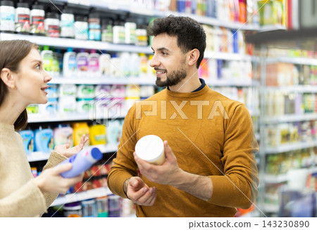 Couple spends time in store, looking for goods and select care product 143230890
