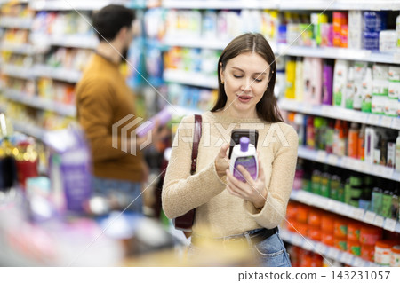 Young woman scanning QR code on care products Young woman scanning QR code on care products 143231057