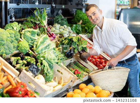 In vegetable department of bio supermarket, male customer took bunch of beets from window In vegetable department of bio supermarket, male customer took bunch of beets from window 143231108