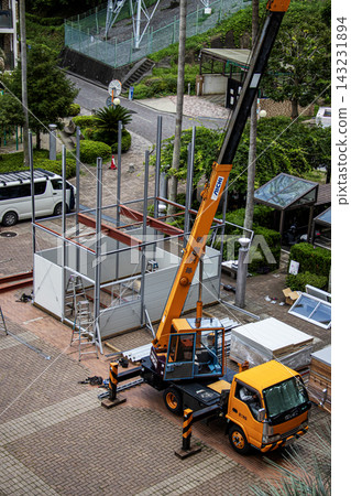 身穿空調工作服的建築工人和鷹架工人在建築工地搭建臨時辦公室。 身穿空調工作服的建築工人和鷹架工人在建築工地搭建臨時辦公室。 143231894