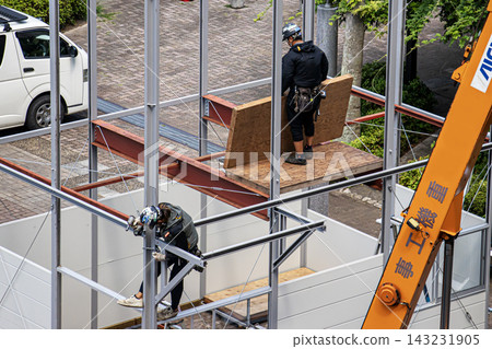 身穿空調工作服的建築工人和鷹架工人在建築工地搭建臨時辦公室。 143231905