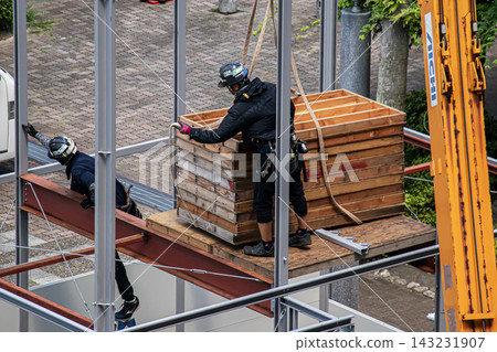 身穿空調工作服的建築工人和鷹架工人在建築工地搭建臨時辦公室。 身穿空調工作服的建築工人和鷹架工人在建築工地搭建臨時辦公室。 143231907