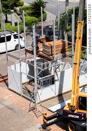 身穿空調工作服的建築工人和鷹架工人在建築工地搭建臨時辦公室。 身穿空調工作服的建築工人和鷹架工人在建築工地搭建臨時辦公室。 143231910
