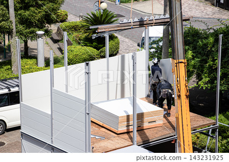 身穿空調工作服的建築工人和鷹架工人在建築工地搭建臨時辦公室。 身穿空調工作服的建築工人和鷹架工人在建築工地搭建臨時辦公室。 143231925
