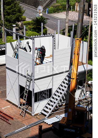 身穿空調工作服的建築工人和鷹架工人在建築工地搭建臨時辦公室。 身穿空調工作服的建築工人和鷹架工人在建築工地搭建臨時辦公室。 143231928