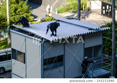 身穿空調工作服的建築工人和鷹架工人在建築工地搭建臨時辦公室。 143231940