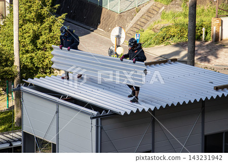 身穿空調工作服的建築工人和鷹架工人在建築工地搭建臨時辦公室。 身穿空調工作服的建築工人和鷹架工人在建築工地搭建臨時辦公室。 143231942