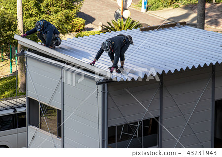 身穿空調工作服的建築工人和鷹架工人在建築工地搭建臨時辦公室。 143231943
