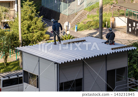 身穿空調工作服的建築工人和鷹架工人在建築工地搭建臨時辦公室。 143231945