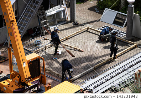 身穿空調工作服的建築工人和鷹架工人在建築工地搭建臨時辦公室。 身穿空調工作服的建築工人和鷹架工人在建築工地搭建臨時辦公室。 143231948