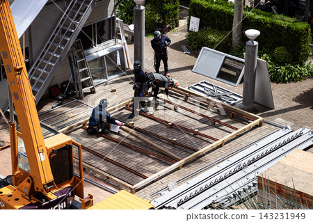 身穿空調工作服的建築工人和鷹架工人在建築工地搭建臨時辦公室。 身穿空調工作服的建築工人和鷹架工人在建築工地搭建臨時辦公室。 143231949