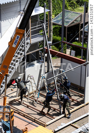 身穿空調工作服的建築工人和鷹架工人在建築工地搭建臨時辦公室。 身穿空調工作服的建築工人和鷹架工人在建築工地搭建臨時辦公室。 143231957