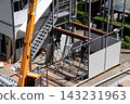 身穿空調工作服的建築工人和鷹架工人在建築工地搭建臨時辦公室。 143231963