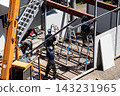 身穿空調工作服的建築工人和鷹架工人在建築工地搭建臨時辦公室。 143231965