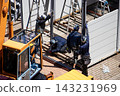 身穿空調工作服的建築工人和鷹架工人在建築工地搭建臨時辦公室。 143231969