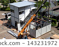 身穿空調工作服的建築工人和鷹架工人在建築工地搭建臨時辦公室。 143231972