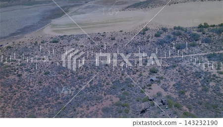 Showing midground band of white posts stretching across arid shrubland with rock outcrops Showing midground band of white posts stretching across arid shrubland with rock outcrops 143232190