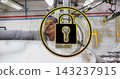 Leaning worker in coat, patterned scarf inspecting white roll on factory line, with padlock overlay 143237915