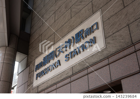The sophisticated station sign for "Nishitetsu Fukuoka (Tenjin) Station South Exit" stands out against the luxurious stone wall. The sophisticated station sign for "Nishitetsu Fukuoka (Tenjin) Station South Exit" stands out against the luxurious stone wall. 143239684