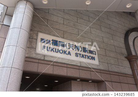 The sophisticated station sign for "Nishitetsu Fukuoka (Tenjin) Station South Exit" stands out against the luxurious stone wall. The sophisticated station sign for "Nishitetsu Fukuoka (Tenjin) Station South Exit" stands out against the luxurious stone wall. 143239685