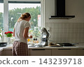 Woman preparing ingredients for baking at kitchen counter with stand mixer 143239718