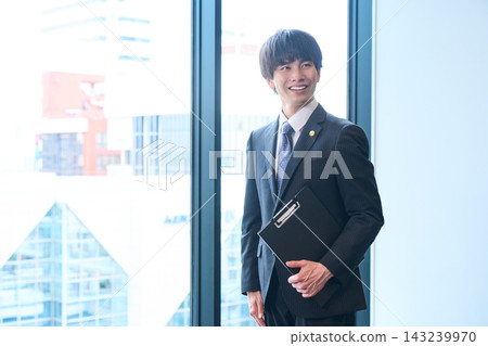 一位胸前佩戴徽章、面帶可靠微笑、職業男性的肖像。 一位胸前佩戴徽章、面帶可靠微笑、職業男性的肖像。 143239970