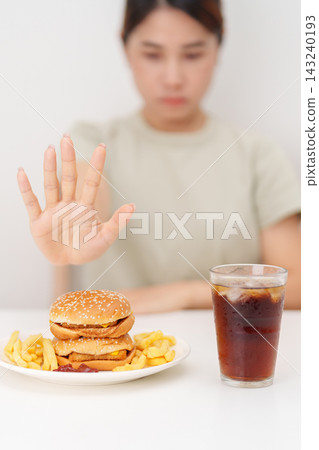 Unhappy woman showing Rejecting and refusing with Juicy beef burger, potato chips and carbonated Soft drinks. Unhealthy, High calorie, Fast food craving, Obesity, diet, weight loss and junk food Unhappy woman showing Rejecting and refusing with Juicy beef burger, potato chips and carbonated Soft drinks. Unhealthy, High calorie, Fast food craving, Obesity, diet, weight loss and junk food 143240193