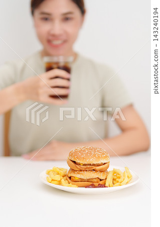 woman eating Juicy beef burger with melted cheddar cheese, potato chips and carbonated Soft drinks. Unhealthy, High calorie, Fast food craving, Obesity, diet, weight loss, junk food and lifestyle woman eating Juicy beef burger with melted cheddar cheese, potato chips and carbonated Soft drinks. Unhealthy, High calorie, Fast food craving, Obesity, diet, weight loss, junk food and lifestyle 143240194