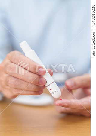 Hand using lancet pen on finger with Blood drop glucose testing or Diabetes checking by digital blood glucose meter. blood sugar level, Diabetes Day, Glycemia, Hypoglycemia, Hyperglycemia and insulin Hand using lancet pen on finger with Blood drop glucose testing or Diabetes checking by digital blood glucose meter. blood sugar level, Diabetes Day, Glycemia, Hypoglycemia, Hyperglycemia and insulin 143240220