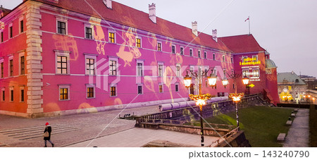 Long pink historic building with projected light patterns and a lit pathway at dusk - Warsaw, Poland - January 26, 2023 Long pink historic building with projected light patterns and a lit pathway at dusk - Warsaw, Poland - January 26, 2023 143240790