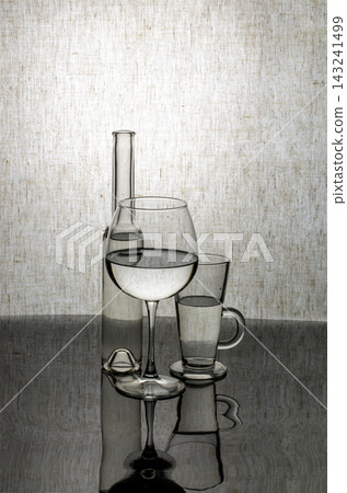 Glassware with liquid on a tabletop with reflection Glassware with liquid on a tabletop with reflection 143241499