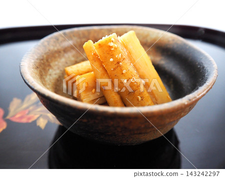 一碗搗碎的牛蒡根，盛裝在日式盤子和黑色托盤中。 143242297