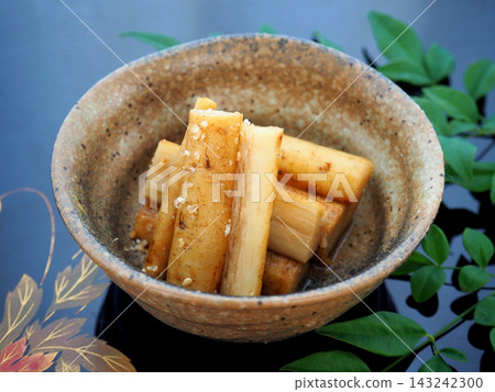 一碗搗碎的牛蒡根,盛裝在日式盤子和黑色托盤中。 一碗搗碎的牛蒡根,盛裝在日式盤子和黑色托盤中。 143242300