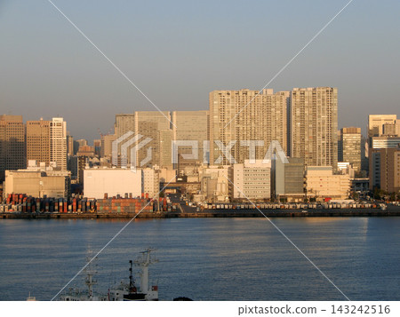 清晨的橘色陽光灑在東京灣沿岸的建築物上。 清晨的橘色陽光灑在東京灣沿岸的建築物上。 143242516