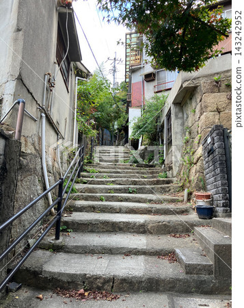 日本住宅區內,兩棟建築之間狹窄的混凝土樓梯。 日本住宅區內,兩棟建築之間狹窄的混凝土樓梯。 143242952