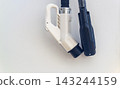 Modern electric vehicle charging station connectors hanging on clean white terminal wall with copy space 143244159