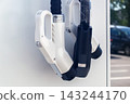 Close up of electric vehicle charging station plugs at public parking lot on sunny summer day 143244170