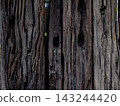 Close up of old distressed wood surface with natural dark brown patterns. 143244420