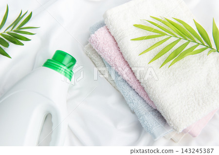 Laundry detergent bottle with fresh towels and green leaf Laundry detergent bottle with fresh towels and green leaf 143245387