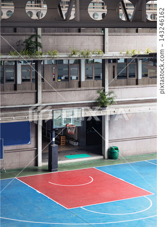 a uniquely sheltered basketball court framed by brutalist concrete architecture. Soft natural light filters down onto the crisp geometric lines of the court, where deep crimson and cool azure tones a uniquely sheltered basketball court framed by brutalist concrete architecture. Soft natural light filters down onto the crisp geometric lines of the court, where deep crimson and cool azure tones 143246162